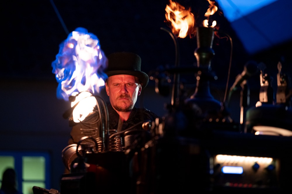 A blue flame rising next to Hjalte at the machine